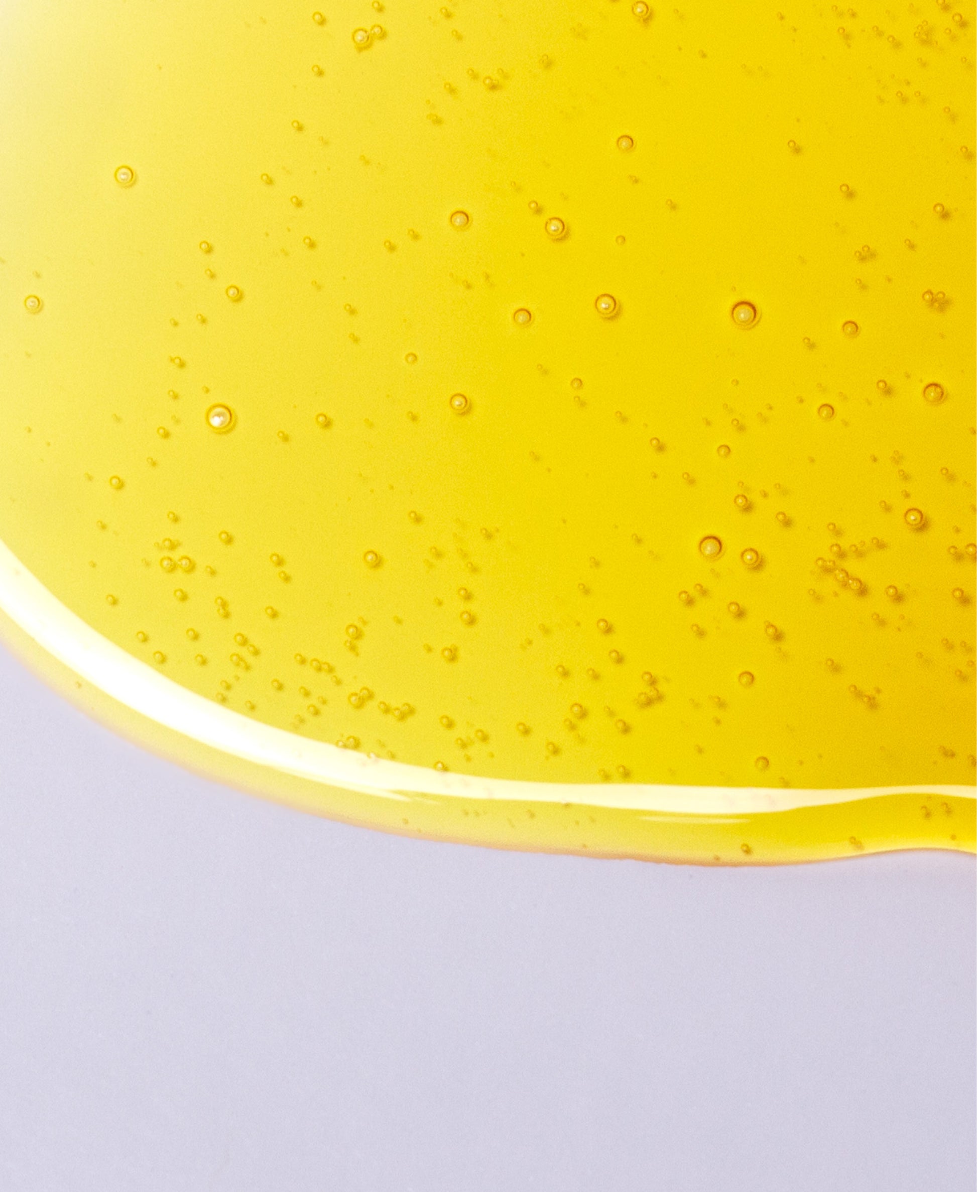 Close up of NEAP Extreme Sour collagen protein gel's honey-like texture on a gray background.