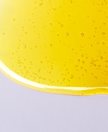 Close up of NEAP Extreme Sour collagen protein gel's honey-like texture on a gray background.