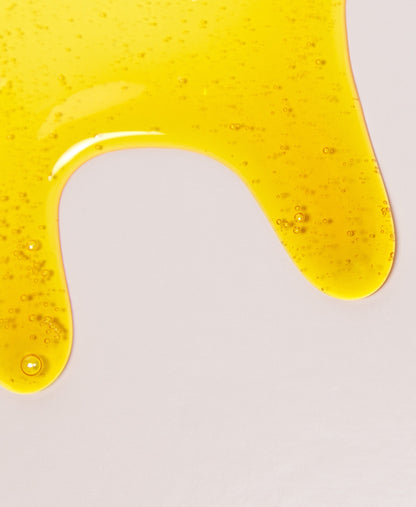 Close up of NEAP Original collagen protein gel's honey-like texture on a neutral background.