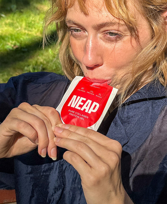 Person eating a NEAP pure collagen complete protein gel pouch on the go outdoors